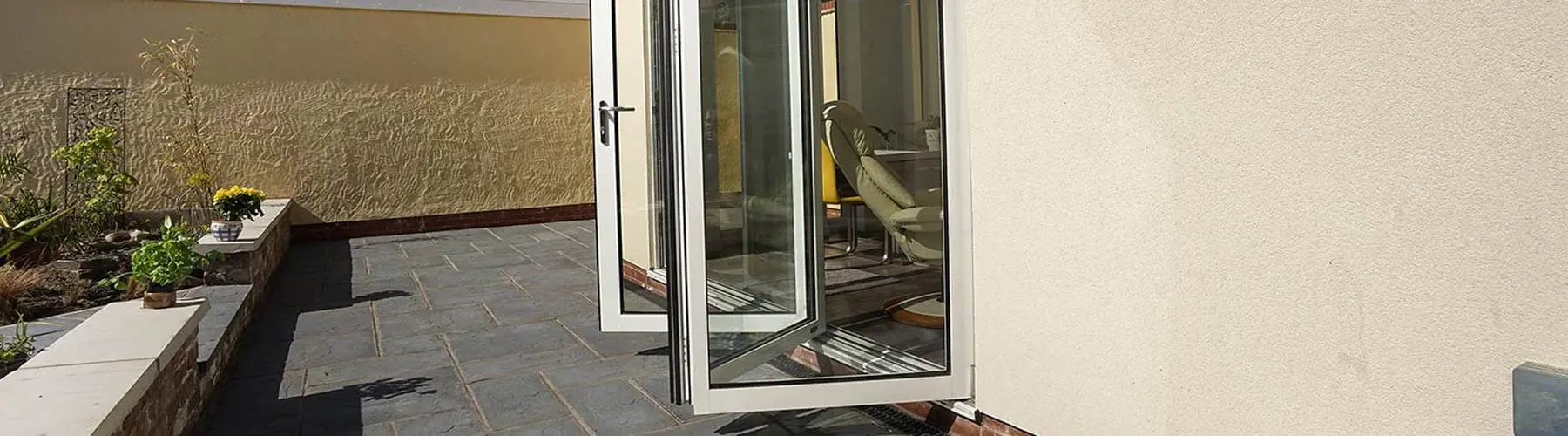 Three door UPVC bifold installed in a k-rend orangery in Hoylake, Wirral.
