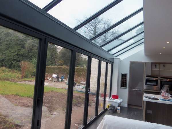 GRAND DESIGN CONSTRUCTION : Internal view of Centor Aluminium Bi fold doors double glazed ; K2 Foiled and bespoke sprayed . self clean glass. Aluminium pressing to cover steel work