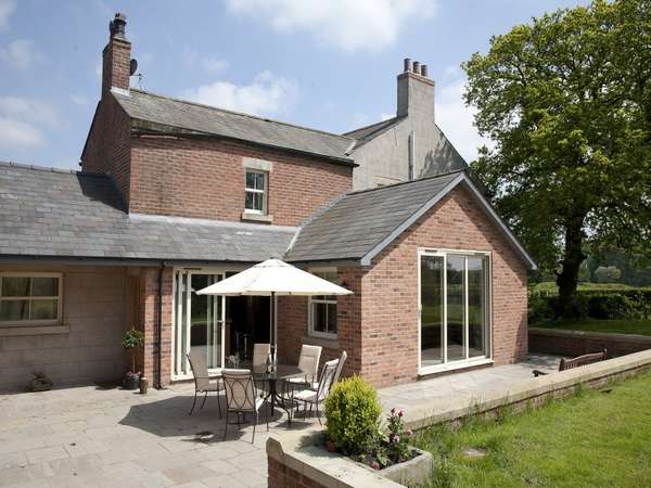 Malpas, Cheshire. close up photo ao an Installation of Slimfold A10 Aluiminium Bi fold doors and matching windows, double glazed with argon gas filled units. Marine coated Polyester powder coated RAL 1015