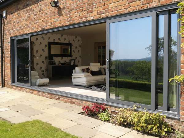 Delamere Cheshire : Installtion of Allstyle Large Sliding Doors, double glazed with celcius Clear self cleaning units. U value 1. Marine finish Polyester Powder coated Alumnium Ral 7012